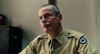 Movie still from “The Master” (2012), directed by Paul Thomas Anderson – An older man with a mustache wearing a tan uniform; Close Up shot, Low angle