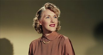 Movie still from “The Master” (2012), directed by Paul Thomas Anderson – An older woman wearing a brown shirt and a pearl necklace; Close Up shot, Low angle
