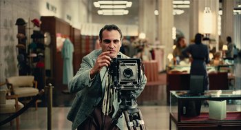 Movie still from “The Master” (2012), directed by Paul Thomas Anderson – A man is taking a picture with an old fashioned camera; Medium shot, Low angle