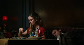 Movie still from “The Master” (2012), directed by Paul Thomas Anderson – A man and a woman sitting at a dinner table; Medium shot, Low angle
