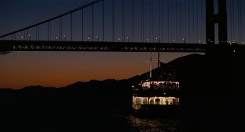 Movie still from “The Master” (2012), directed by Paul Thomas Anderson – A boat under a suspension bridge at night; Extreme Wide shot, Low angle