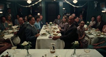 Movie still from “The Master” (2012), directed by Paul Thomas Anderson – A group of people sitting at a table with plates of food on it; Wide shot, High angle