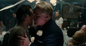 Movie still from “The Master” (2012), directed by Paul Thomas Anderson – A man in a suit kissing another man in a suit; Close Up shot, Over the shoulder angle
