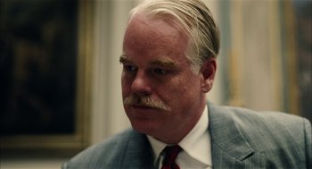 Movie still from “The Master” (2012), directed by Paul Thomas Anderson – A man with a mustache wearing a suit; Close Up shot, Over the shoulder angle