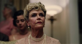 Movie still from “The Master” (2012), directed by Paul Thomas Anderson – An older woman wearing pearls and a lace dress; Close Up shot, Low angle
