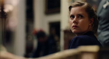 Movie still from “The Master” (2012), directed by Paul Thomas Anderson – A woman sitting on a bench looking at the camera; Close Up shot, Over the shoulder angle