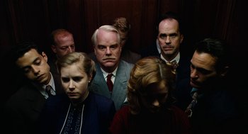 Movie still from “The Master” (2012), directed by Paul Thomas Anderson – A group of people standing around each other in an elevator; Medium shot, Overhead angle