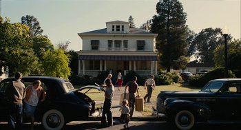 Movie still from “The Master” (2012), directed by Paul Thomas Anderson – A group of people standing on the side of a road; Extreme Wide shot, Low angle