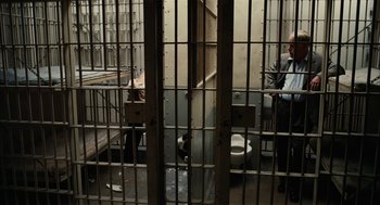 Movie still from “The Master” (2012), directed by Paul Thomas Anderson – A man sitting in a jail cell next to a toilet; Wide shot, High angle