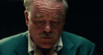 Movie still from “The Master” (2012), directed by Paul Thomas Anderson – An older man in a green jacket and a yellow tie; Close Up shot, Over the shoulder angle