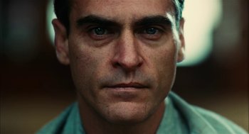 Movie still from “The Master” (2012), directed by Paul Thomas Anderson – A man's face in a green shirt; Close Up shot, Low angle