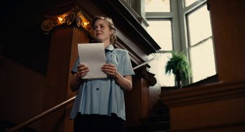 Movie still from “The Master” (2012), directed by Paul Thomas Anderson – A woman holding a piece of paper while standing in front of a staircase; Medium shot, Low angle