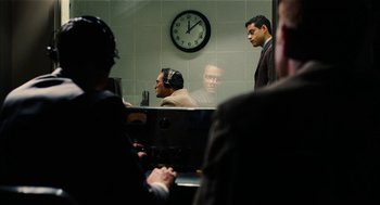 Movie still from “The Master” (2012), directed by Paul Thomas Anderson – A group of men sitting in front of a wall clock; Wide shot, Over the shoulder angle