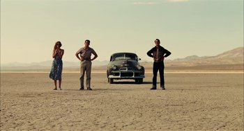 Movie still from “The Master” (2012), directed by Paul Thomas Anderson – A group of people standing in front of an old car; Wide shot, Low angle
