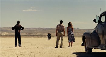 Movie still from “The Master” (2012), directed by Paul Thomas Anderson – A man and a woman standing in the desert looking at a motorcycle; Extreme Wide shot, Over the shoulder angle
