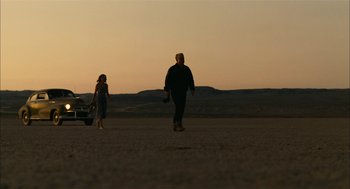 Movie still from “The Master” (2012), directed by Paul Thomas Anderson – A man and a woman walking across a road; Wide shot, Low angle