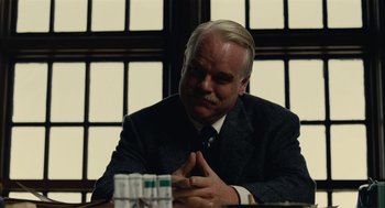 Movie still from “The Master” (2012), directed by Paul Thomas Anderson – A man sitting at a table in front of a window; Close Up shot, Over the shoulder angle