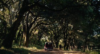 Movie still from “The Master” (2012), directed by Paul Thomas Anderson – An old car is parked on the side of the road; Extreme Wide shot, High angle