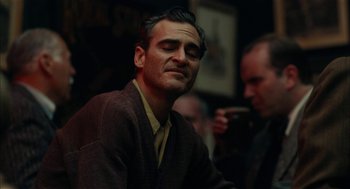 Movie still from “The Master” (2012), directed by Paul Thomas Anderson – A person sitting in front of a camera; Close Up shot, Over the shoulder angle