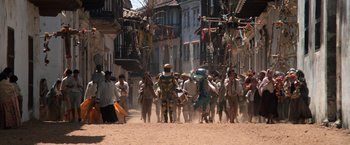 Movie still from “The Mission” (1986), directed by Roland Joffé – A group of people walking down a street; Extreme Wide shot, High angle