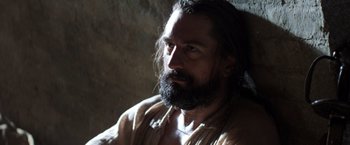 Movie still from “The Mission” (1986), directed by Roland Joffé – A man with long hair and a long beard; Close Up shot, Low angle