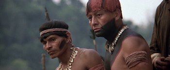 Movie still from “The Mission” (1986), directed by Roland Joffé – Two men in traditional clothing standing next to each other; Close Up shot, Low angle