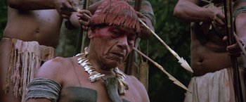 Movie still from “The Mission” (1986), directed by Roland Joffé – A man with a red hat and a necklace on his neck; Close Up shot, Low angle