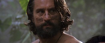 Movie still from “The Mission” (1986), directed by Roland Joffé – A person with tattoos on their face; Close Up shot, Low angle
