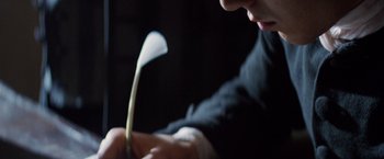 Movie still from “The Mission” (1986), directed by Roland Joffé – A person writing on a piece of paper; Extreme Close Up shot, High angle