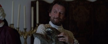 Movie still from “The Mission” (1986), directed by Roland Joffé – A bearded man holding a sloth in his arms; Close Up shot, Low angle