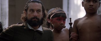 Movie still from “The Mission” (1986), directed by Roland Joffé – A man and a boy with face paint; Close Up shot, Over the shoulder angle