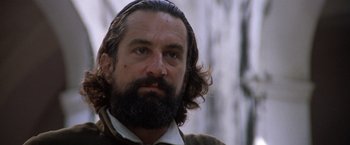 Movie still from “The Mission” (1986), directed by Roland Joffé – A man with long hair and a beard looking to his left; Close Up shot, Low angle