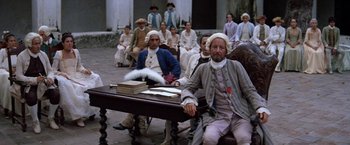 Movie still from “The Mission” (1986), directed by Roland Joffé – A group of people sitting around a table; Wide shot, High angle