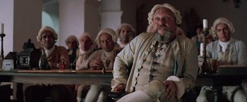 Movie still from “The Mission” (1986), directed by Roland Joffé – A group of men sitting next to each other; Medium shot, Low angle