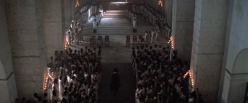 Movie still from “The Mission” (1986), directed by Roland Joffé – A crowd of people standing in a large room; Extreme Wide shot, High angle