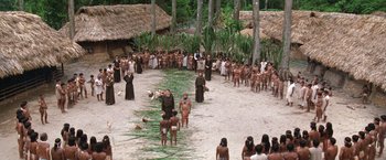 Movie still from “The Mission” (1986), directed by Roland Joffé – A group of people standing in a field with trees; Extreme Wide shot, High angle