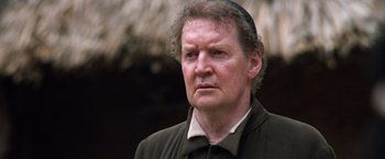 Movie still from “The Mission” (1986), directed by Roland Joffé – An older man wearing a hat and looking at the camera; Close Up shot, Low angle