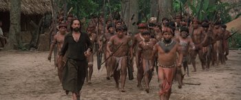 Movie still from “The Mission” (1986), directed by Roland Joffé – A group of people walking down a dirt road; Wide shot, High angle