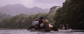 Movie still from “The Mission” (1986), directed by Roland Joffé – A group of people in a boat on a body of water; Extreme Wide shot, High angle