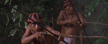 Movie still from “The Mission” (1986), directed by Roland Joffé – Two men are holding bows and arrows in their hands; Medium shot, High angle