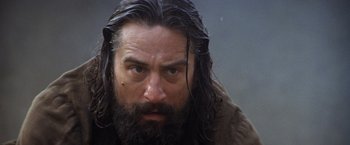Movie still from “The Mission” (1986), directed by Roland Joffé – A man with long hair and a long beard; Close Up shot, Low angle