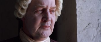 Movie still from “The Mission” (1986), directed by Roland Joffé – An old man with a white wig and a white beard; Close Up shot, High angle