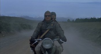 Movie still from “The Motorcycle Diaries” (2004), directed by Walter Salles – A man and a woman riding a motorcycle on a dirt road; Wide shot, Low angle