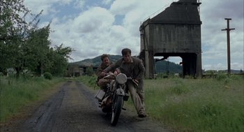 Movie still from “The Motorcycle Diaries” (2004), directed by Walter Salles – A man and a woman riding a motorcycle down a dirt road; Wide shot, Low angle