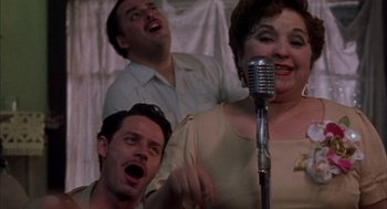 Movie still from “The Motorcycle Diaries” (2004), directed by Walter Salles – A group of men and women singing in front of a microphone; Close Up shot, Low angle