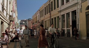 Movie still from “The Motorcycle Diaries” (2004), directed by Walter Salles – A group of people walking down a street near a building; Extreme Wide shot, High angle