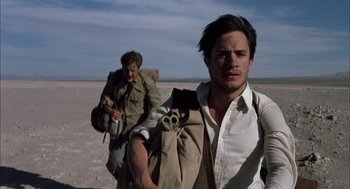Movie still from “The Motorcycle Diaries” (2004), directed by Walter Salles – A man walking across a desert with a backpack; Medium shot, Low angle