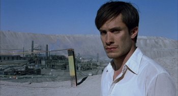 Movie still from “The Motorcycle Diaries” (2004), directed by Walter Salles – A man standing in the dirt near a factory; Close Up shot, Low angle