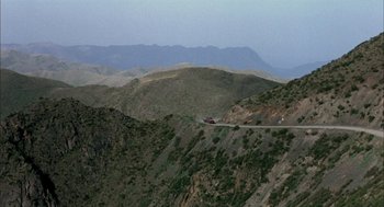 Movie still from “The Motorcycle Diaries” (2004), directed by Walter Salles – A truck driving down a road on a mountain side; Extreme Wide shot, High angle