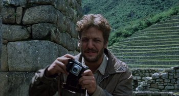Movie still from “The Motorcycle Diaries” (2004), directed by Walter Salles – A man holding a camera in front of a stone wall; Close Up shot, Low angle
